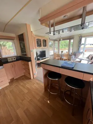a kitchen and living room of a tiny house at Dedham Lodge in Lawford