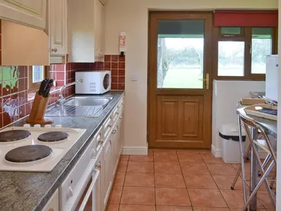 a kitchen with a stove and a counter top at Meadowview Cottage in Saint Osyth