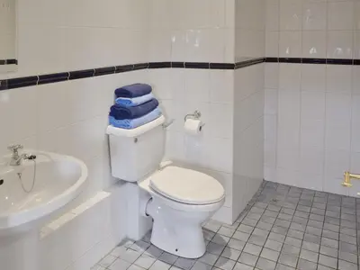 a white bathroom with a toilet and a sink at Meadowview Cottage in Saint Osyth