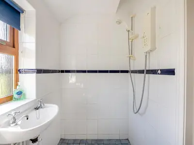 a bathroom with a sink and a shower at Appletree Cottage in Saint Osyth
