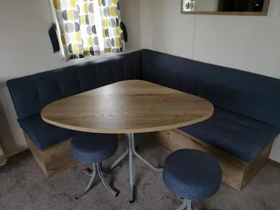 a wooden table and two blue chairs in a room at 709 Seawick in Jaywick Sands