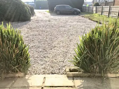 a gravel driveway with a car parked in a yard at Stanford Villa in Stanford le Hope