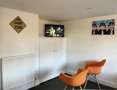 a room with two chairs and a cabinet and a sign at Stanford Villa in Stanford le Hope