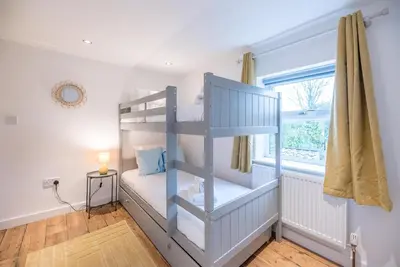a bedroom with a bunk bed and a window at Lily Cottage, Leiston in Leiston