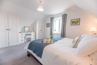 a bedroom with a large white bed with a tray on it at Rest Ashored, Aldeburgh in Aldeburgh