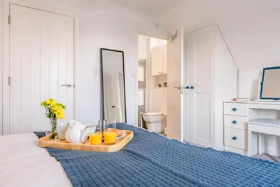 a room with a bed with a tray with drinks on it at Rest Ashored, Aldeburgh in Aldeburgh