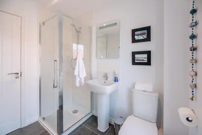 a bathroom with a shower and a toilet and a sink at Rest Ashored, Aldeburgh in Aldeburgh