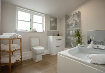a bathroom with a tub and a toilet and a sink at City to Country Retreat Luxury Cottage with Hot Tub in Toppesfield