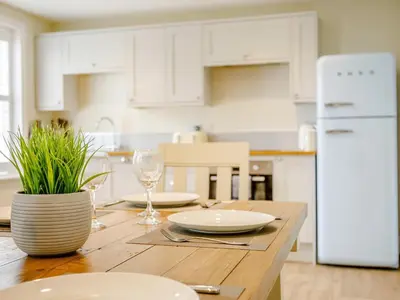 a kitchen with a wooden table with plates and wine glasses at City to Country Retreat Luxury Cottage with Hot Tub in Toppesfield