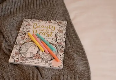 a book on beauty and the past with two pencils at City to Country Retreat Luxury Cottage with Hot Tub in Toppesfield