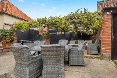 a patio with wicker chairs and a table with a grill at 5 Bed in Bramfield oc-sftmh in Bramfield