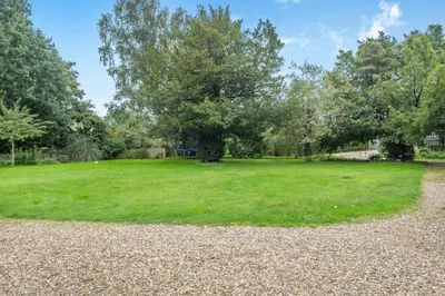 a large grassy field with a tree in the middle at 5 Bed in Bramfield oc-sftmh in Bramfield