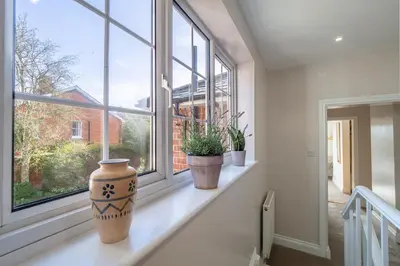 a window sill with three potted plants on it at Adorable cottage with a log burner in heavenly village - Constable Lodge in Nayland
