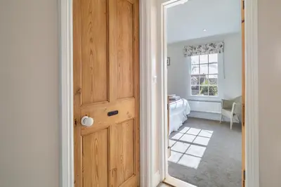 a wooden door in a room with a bedroom at Adorable cottage with a log burner in heavenly village - Constable Lodge in Nayland