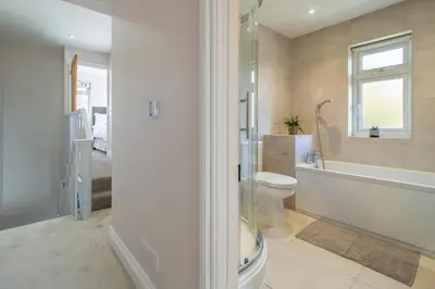 a bathroom with a toilet and a tub and a sink at Adorable cottage with a log burner in heavenly village - Constable Lodge in Nayland