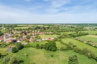 an aerial view of a small village in a green field at Adorable cottage with a log burner in heavenly village - Constable Lodge in Nayland