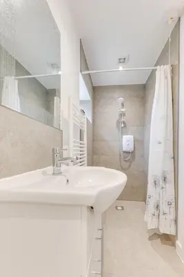 a white bathroom with a sink and a shower at 1 Bed in Great Waldingfield oc-ac1 in Great Waldingfield