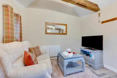 a living room with a white couch and a tv at 1 Bed in Great Waldingfield oc-ac1 in Great Waldingfield