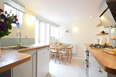 a kitchen with a sink and a table with chairs at Seaflower, Aldeburgh in Aldeburgh