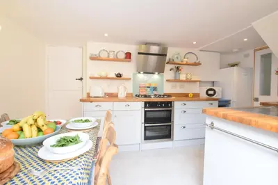 a kitchen with a table with a bowl of fruit on it at Seaflower, Aldeburgh in Aldeburgh