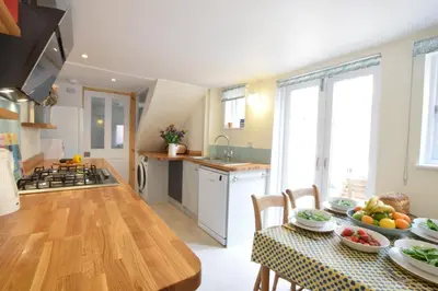 a kitchen and dining room with a table with food on it at Seaflower, Aldeburgh in Aldeburgh