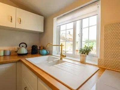 a kitchen with a sink and a window at Bluebird Cottage in Higham