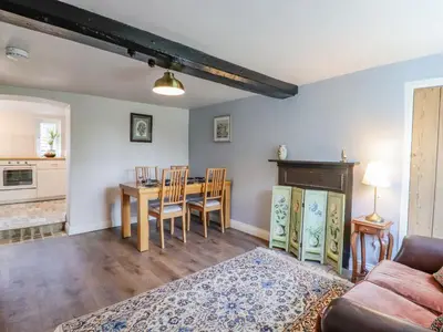 a living room with a table and a couch at Bluebird Cottage in Higham