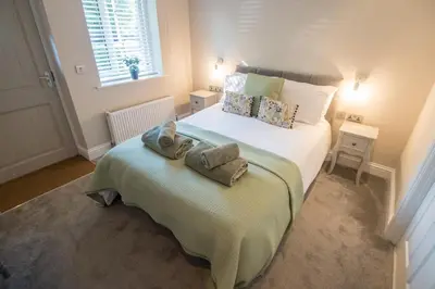 a bedroom with a bed with towels on it at The Foxes Den in Assington