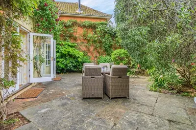 a patio with wicker chairs and a table in front of a building at 3 Bed in Aldeburgh oc-spcot in Aldeburgh