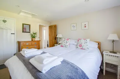 a bedroom with a large white bed with towels on it at 1 Bed in Debach oc-lasn in Debach