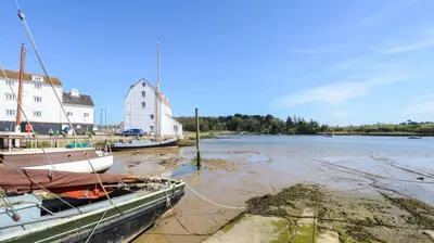 two boats are docked on the shore of a river at 1 Bed in Debach oc-lasn in Debach