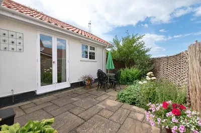 a patio with two chairs and a table in front of a house at 1 Bed in Debach oc-lasn in Debach