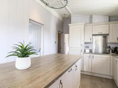 a kitchen with white cabinets and a potted plant at Skylarks in Hengrave