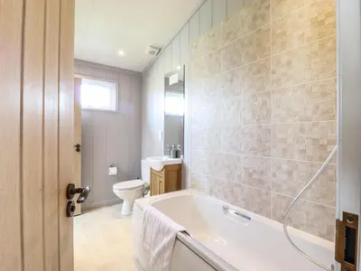 a bathroom with a tub and a toilet at Skylarks in Hengrave