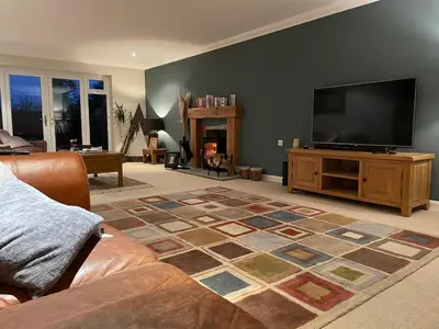 a living room with a couch and a flat screen tv at Executive home with plenty of room in Ely