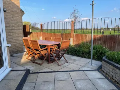 a wooden table and chairs on a patio at Executive home with plenty of room in Ely