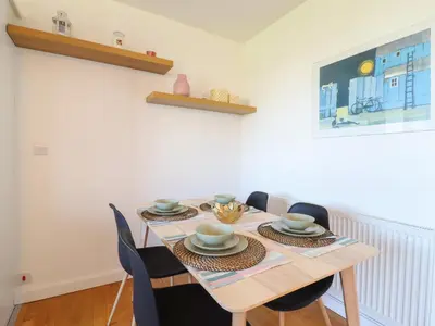 a dining room with a wooden table and chairs at Flat 19 By The Beach in Harwich
