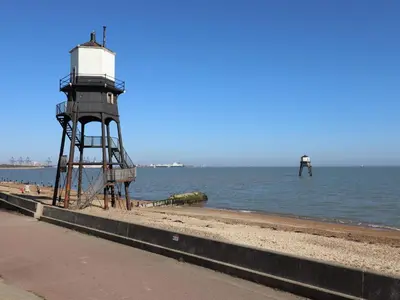 a lighthouse on the shore of a beach at Flat 19 By The Beach in Harwich