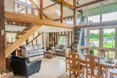 a living room with a staircase and a table and chairs at Moles Meadow in Middleton
