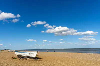 a boat sitting on a sandy beach next to the ocean at Moles Meadow in Middleton