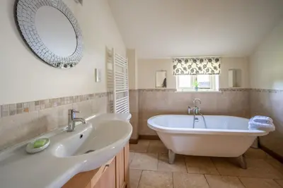 a white bathroom with a tub and a sink at Moles Meadow in Middleton