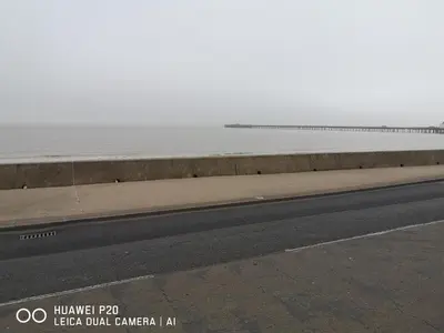a road next to a beach with the ocean at Lovely 2-Bed caravan in Walton on the Naze in Walton-on-the-Naze
