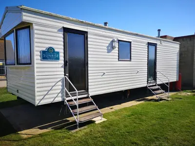 a white trailer with a sign on the side of it at Lovely 2-Bed caravan in Walton on the Naze in Walton-on-the-Naze