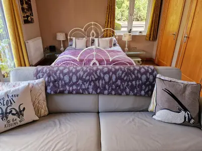 a couch with a purple blanket on top of a bed at The Goat House in Purleigh