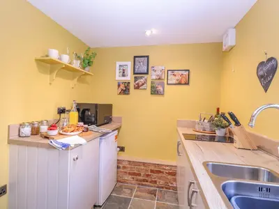 a kitchen with yellow walls and a sink at The Forge in Stowmarket
