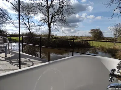 a bath tub with a view of a river at The Water Shack - Amazing tiny house retreat in Woodbridge
