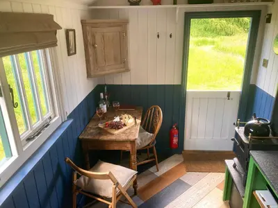 a kitchen with a table with a bowl of fruit on it at Stompy's Hut in Laxfield
