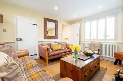 a living room with a couch and a table at Pebble Cottage - 6 Victoria Rd - Aldeburgh Coastal Cottages in Aldeburgh