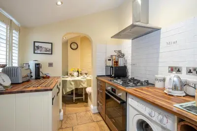 a kitchen with a sink and a stove top oven at Pebble Cottage - 6 Victoria Rd - Aldeburgh Coastal Cottages in Aldeburgh