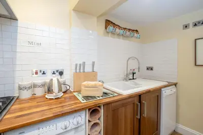 a kitchen with a sink and a counter top at Pebble Cottage - 6 Victoria Rd - Aldeburgh Coastal Cottages in Aldeburgh